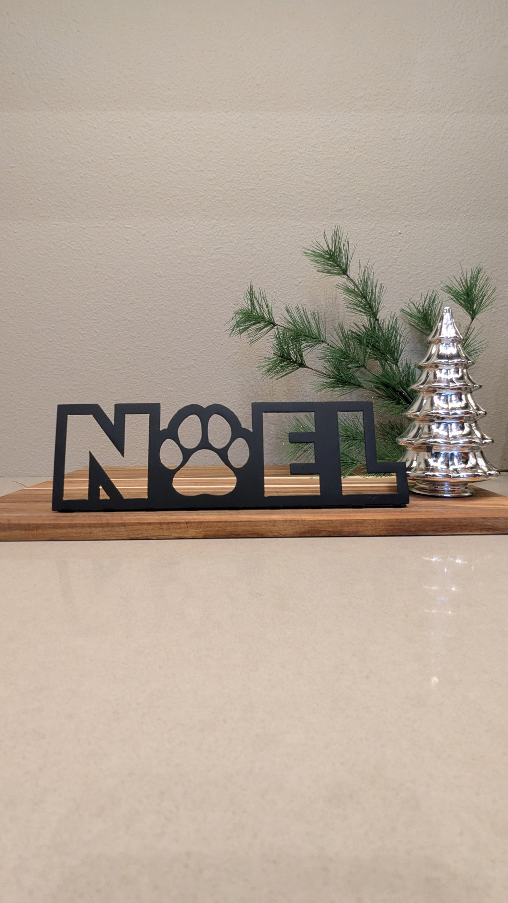 Image of a  black metal sign of the word "NOEL" and a paw for the "o" from Atomic Rat Rods & Metal Werks.