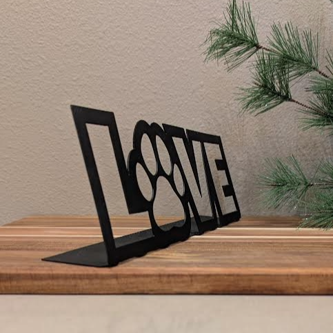 Front quarter image of a  black metal sign of the word "LOVE" and a paw for the "o" from Atomic Rat Rods & Metal Werks.