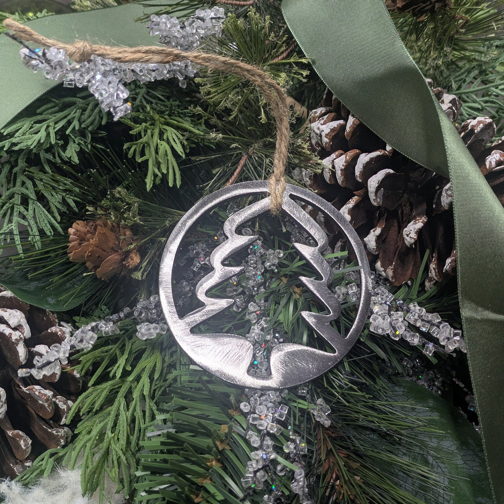 Simple, silver-colored, minimalist, metal tree ornament on a Christmas tree from Atomic Rat Rods & Metal Werks.